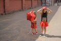 The child laughs merrily putting a cap on his head. The girl holds a balloon in the shape of a star in her hand.