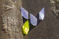 The child launched paper boats made of white and yellow paper into the stream