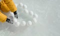 The child lays out heart-shaped snowballs on the ice Royalty Free Stock Photo