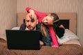 A child lays a toy spider on a manÃ¢â¬â¢s head. Daughter prevents dad from working on a computer. Little girl scares father with an Royalty Free Stock Photo