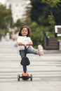 Child learn to ride scooter in a park on sunny summer day Royalty Free Stock Photo