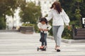 Child learn to ride scooter in a park on sunny summer day Royalty Free Stock Photo