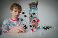 Child learning chemistry, making model of a molecule, engineering and STEM