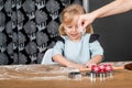 Child Learning Holiday Baking While Sprinkling Flour During Cookie Preparation Royalty Free Stock Photo