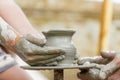 Child learning how to make a pot, old potter h