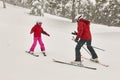 Child learning how to ski with an instructor. Winter Royalty Free Stock Photo