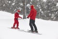 Child learning how to ski with instructor. Winter sport Royalty Free Stock Photo