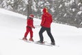 Child learning how to ski with instructor. Winter time Royalty Free Stock Photo