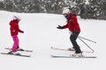 Child learning how to ski with monitor. Winter sport Royalty Free Stock Photo