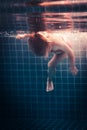 Child learning swimming underwater in swimming pool during diving training overcoming fear of deep Royalty Free Stock Photo