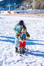 The child learning to ski with mother on the slope in Bansko, Bulgaria