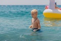 Child learning to swim in the open sea of tropical resort. Kids learn swimming. Exercise and training for young children