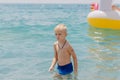 Child learning to swim in the open sea of tropical resort. Kids learn swimming. Exercise and training for young children