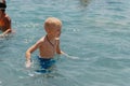 Child learning to swim in the open sea of tropical resort. Kids learn swimming. Exercise and training for young children