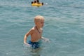 Child learning to swim in the open sea of tropical resort. Kids learn swimming. Exercise and training for young children