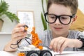 The child learns coding and programming and constructs a robot car, looks with concentration and fixes the control Royalty Free Stock Photo