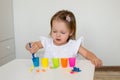 The child learns colors. A little girl sorts the animal figures by color throwing them into the appropriate cup.