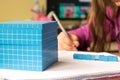 Child learns math, volume and capacity. For learning model uses a three-dimensional cube. Royalty Free Stock Photo