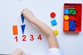 The child learns Number line and geometric shapes. The preschooler works with Montessori material. Educational logic toys for kid Royalty Free Stock Photo