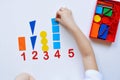 The child learns Number line and geometric shapes. The preschooler works with Montessori material. Educational logic toys for kid