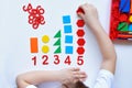 The child learns Number line and geometric shapes. The preschooler works with Montessori material