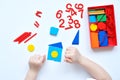 The child learns Number line and geometric shapes. The preschooler works with Montessori material. Educational logic toys for kid