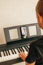 CHILD LEARNS TO PLAY THE PIANO ONLINE Royalty Free Stock Photo