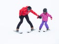 A child learns to ski with a coach in the mountains