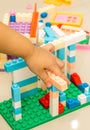 A child left hand playing with colorful plastic bricks Royalty Free Stock Photo