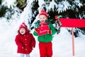 Child with letter to Santa at Christmas mail box in snow Royalty Free Stock Photo