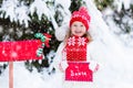 Child with letter to Santa at Christmas mail box in snow Royalty Free Stock Photo