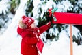 Child with letter to Santa at Christmas mail box in snow Royalty Free Stock Photo