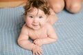 The child lies on a blue bedspread. Little cute girl two months old lying on a blue bedspread and smiling, looking at the camera Royalty Free Stock Photo