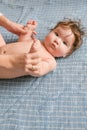 The child lies on a blue bedspread. Little cute girl two months old lying on a blue bedspread and smiling, looking at the camera Royalty Free Stock Photo