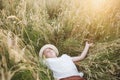 Child lies on field of grain with closed eyes. summer rest in harmony with nature. Royalty Free Stock Photo