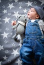 The child lies on a star blanket. Cute newborn baby girl lying in bed. Owl child sleeping on a blue blanket with stars. in Royalty Free Stock Photo