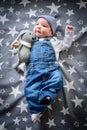 The child lies on a star blanket. Cute newborn baby girl lying in bed. Owl child sleeping on a blue blanket with stars. in Royalty Free Stock Photo