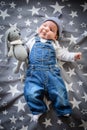 The child lies on a star blanket. Cute newborn baby girl lying in bed. Owl child sleeping on a blue blanket with stars. in Royalty Free Stock Photo