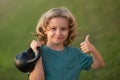 Child lifting the kettlebell in park outside. Child boy working out with dumbbells. Kids sport and active healthy life Royalty Free Stock Photo