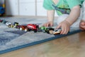 Child lining up toys on the floor at home