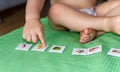 Child lining up toys on the floor at home. Kids education concept