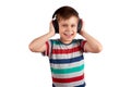 Child listens to his favorite music on headphones and dances to it , isolated on white background. Leisure, music and Royalty Free Stock Photo