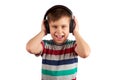 Child listens to his favorite music on headphones and dances to it , isolated on white background. Leisure, music and Royalty Free Stock Photo