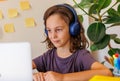 child listens to music at the lesson. Boy with curly hair is happy with distance learning