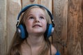 The child listens to music child wooden background listening to music