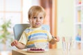 Child little boy eating food with spoon in nursery Royalty Free Stock Photo