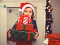 Child little cute girl kid in Santa cap holding a Christmas gift boxes in a hands Royalty Free Stock Photo