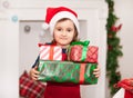 Child little cute girl kid in Santa cap holding a Christmas gift boxes in a hands Royalty Free Stock Photo