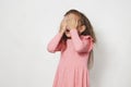 Child little girl covering her eyes by hands against white background Royalty Free Stock Photo