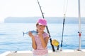 child little girl fishing in boat holding little tunny fish catch Royalty Free Stock Photo